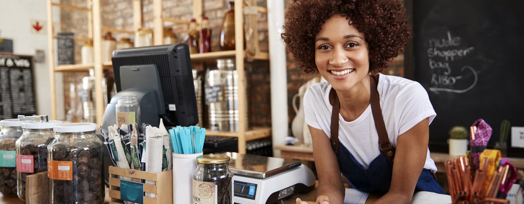 lifestyle image of a women leaning over the counter at a coffee shop